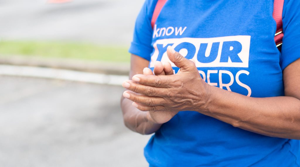 Person clapping hands anwearing a Know Your Numbers t-shirt